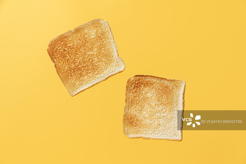 黄色背景上的两片烤面包片图片素材