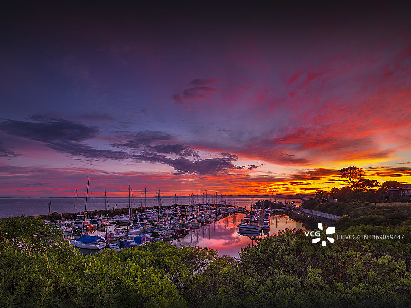 一个金色的黎明炽热的颜色在夏末，在纽黑文游艇俱乐部码头，菲利普岛贝斯海岸，维多利亚，澳大利亚图片素材