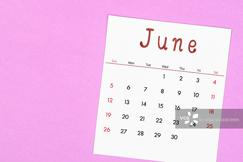 六月是组织者计划和提醒的月份，用洋红色的纸做背景。商业计划预约会议概念图片素材
