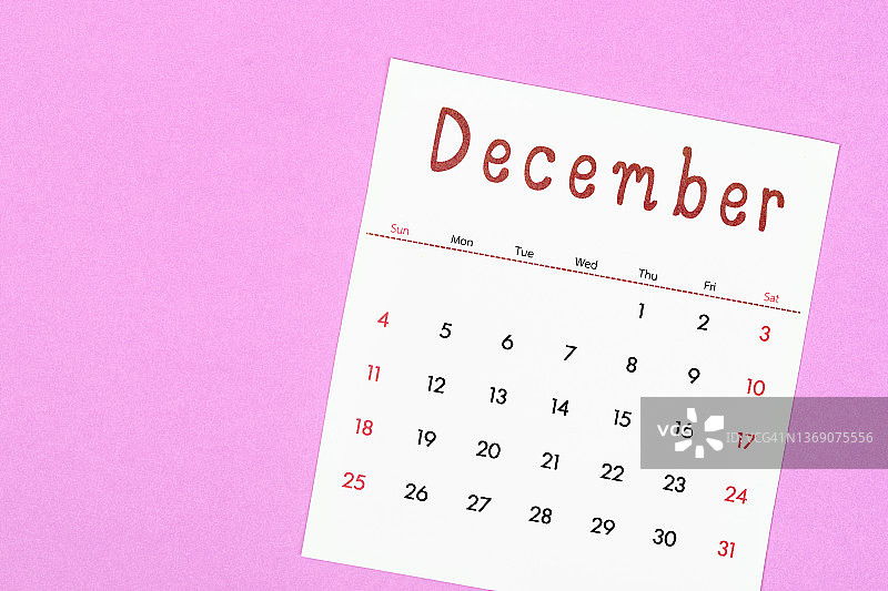 12月是组织者计划和提醒的月份，用洋红色的纸做背景。商业计划预约会议概念图片素材
