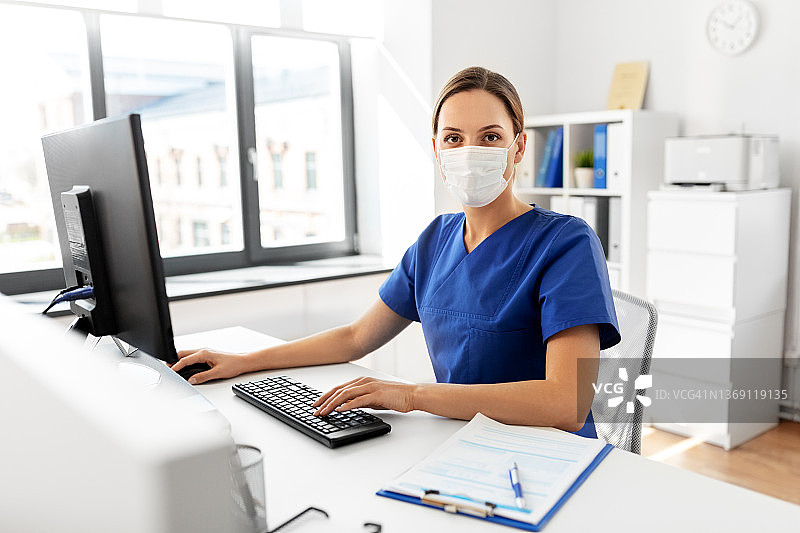 医生或护士戴着口罩在医院使用电脑图片素材