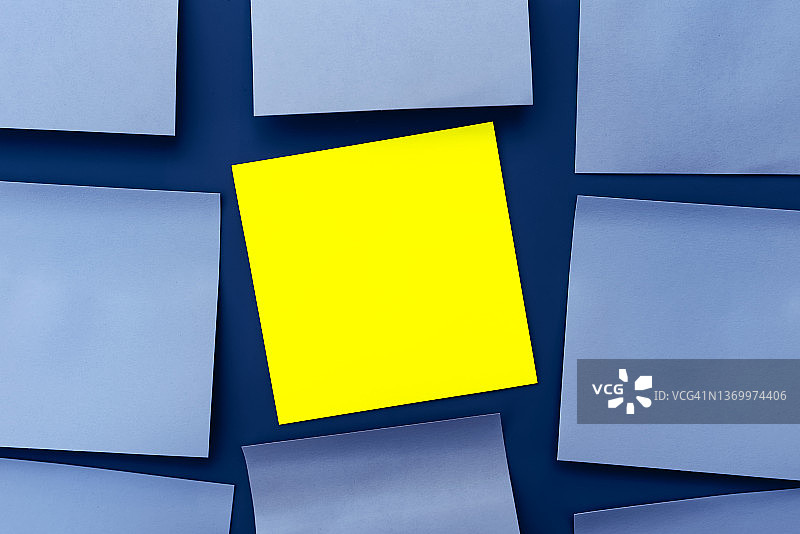 黄色的贴纸是注意力的中心，在蓝色的便签纸上，复制空间图片素材
