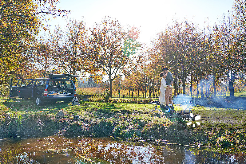 深情的年轻夫妇在阳光明媚的秋野露营图片素材