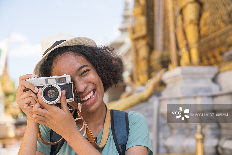带着背包和帽子的女旅行者在她的假期时间里拍摄了卧佛寺的宫殿。图片素材