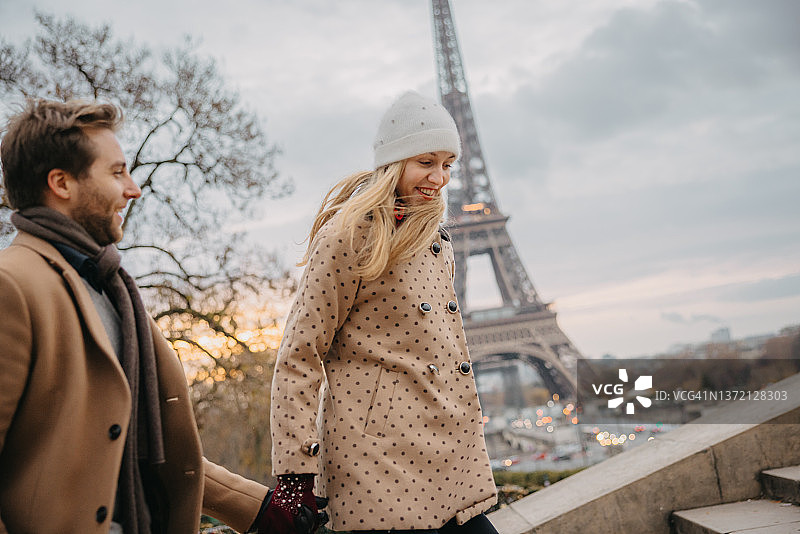 一对微笑的夫妇走上埃菲尔铁塔附近的观景台，巴黎图片素材