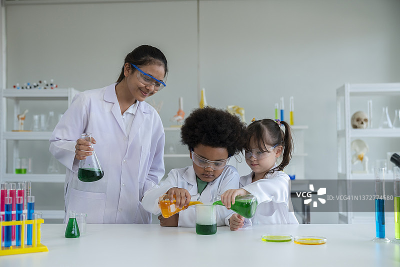 小女孩和小男孩和实验伙伴一起做化学实验。图片素材