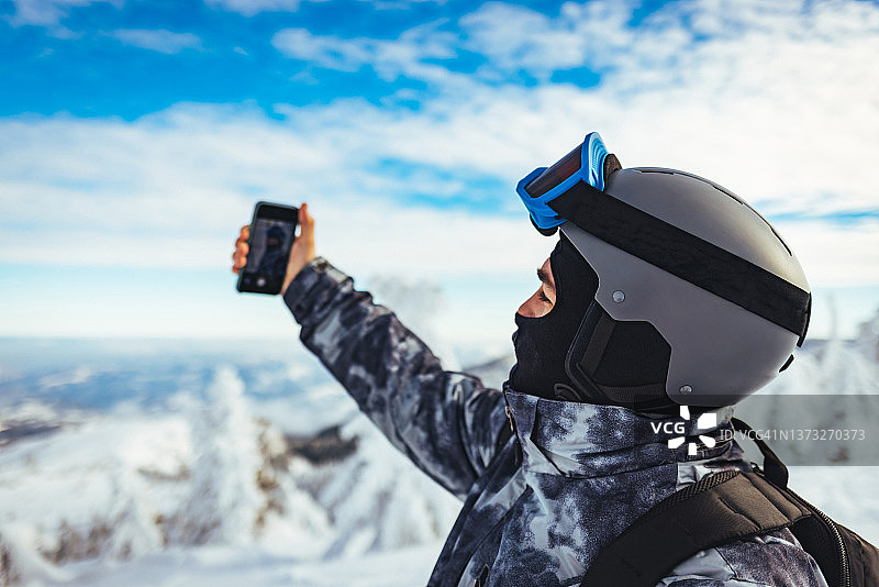 一个穿着滑雪装备的年轻人在自拍图片素材