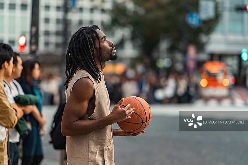 英俊的黑人种族男子与篮球在城市的肖像图片素材