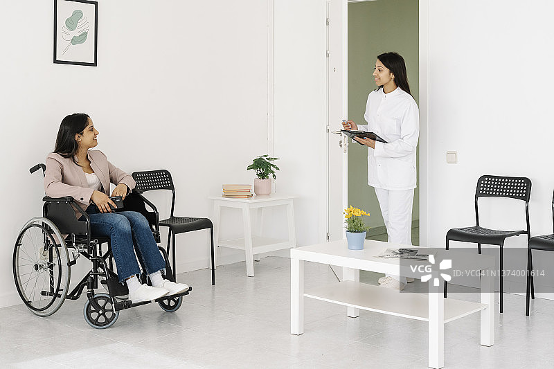 坐在轮椅上的妇女在医疗中心的候诊室里。图片素材