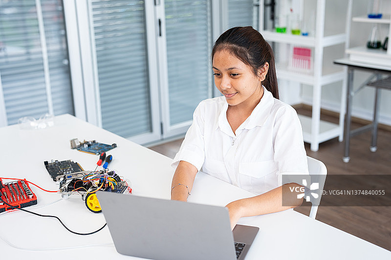 女学生在课后计算机编码课上构建和编程机器人车图片素材