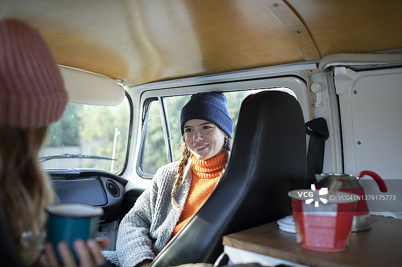 年轻的女性朋友在公路旅行的露营车放松图片素材