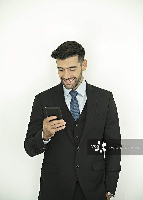 一名商人看着手机的肖像。图片素材