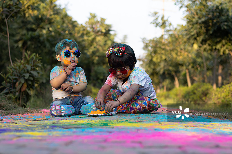 快乐的亚洲印度孩子男孩和女孩享受节日的颜色与胡里彩粉称为Gulal或Rang图片素材