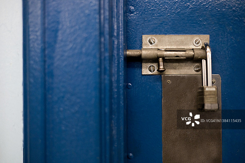 传统的银质不锈钢挂锁锁在学校的大门上图片素材