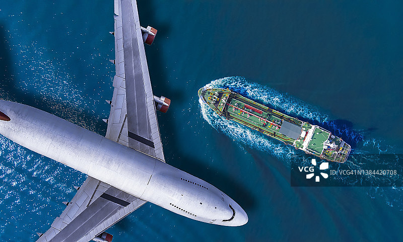 空中俯瞰，客机飞越油轮在海上高速航行。图片素材
