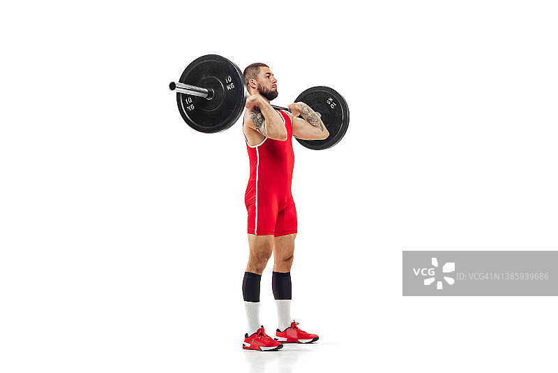 全身像的男人在红色运动服锻炼与体重孤立在白色背景。运动，举重，力量，成就概念图片素材