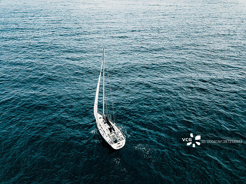 俯瞰豪华游艇在蔚蓝的海面上航行。图片素材