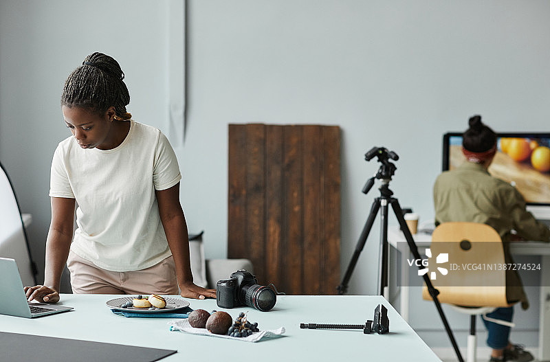 黑人女性摄影师在工作室工作图片素材