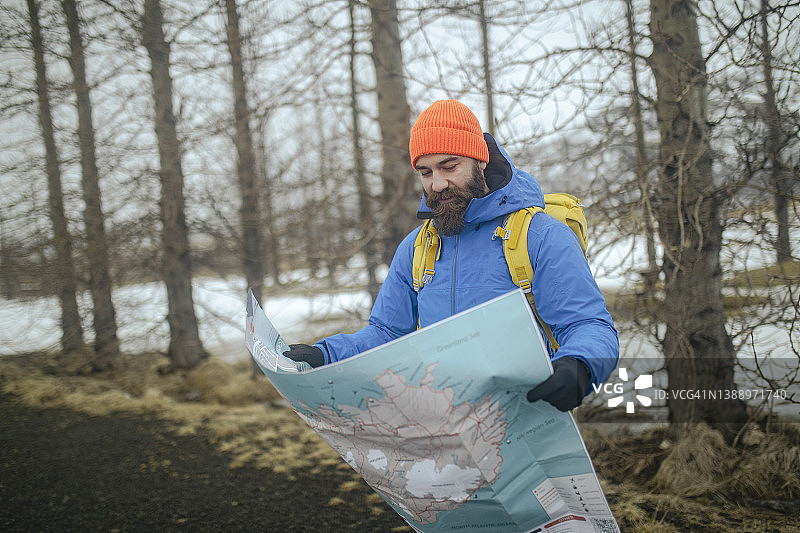 在一个寒冷的冬日，游客们手里拿着地图在冰岛旅游。ISL图片素材