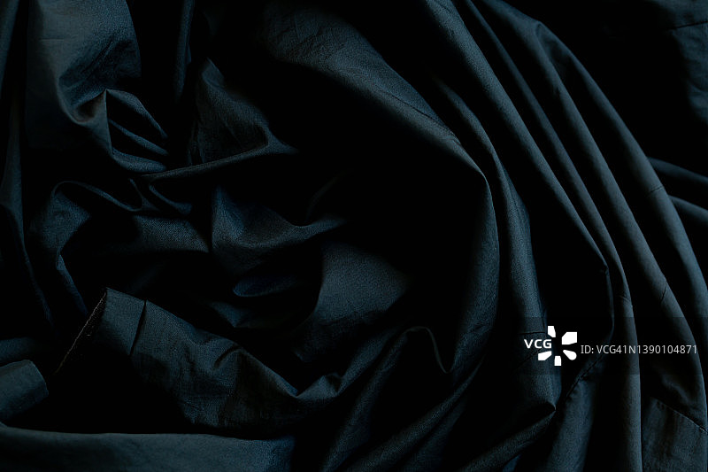 黑色起皱织物表面，近起皱的黑色织物床单纹理背景图片素材