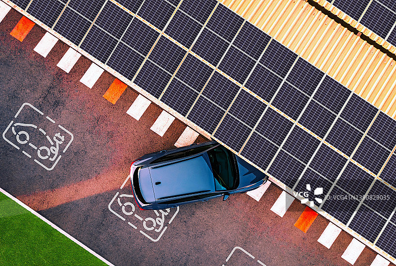 电动汽车在充电站的太阳能电池板的鸟瞰图。图片素材