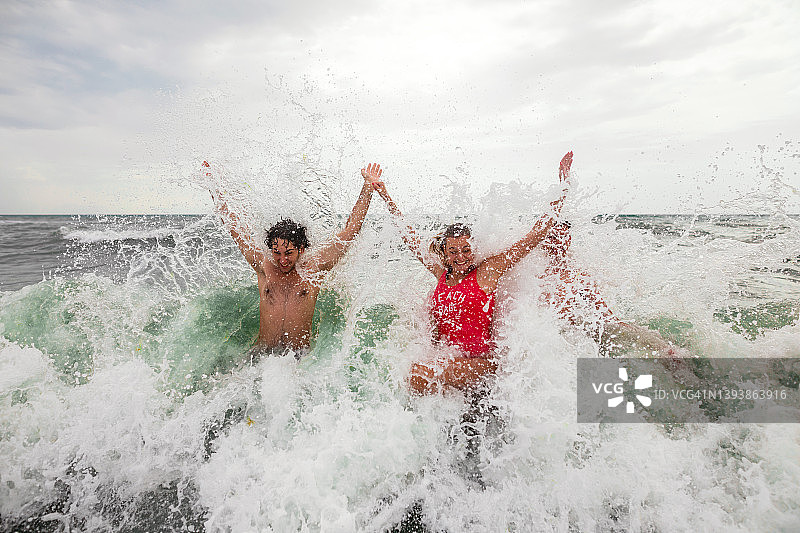 兴奋的年轻朋友们，在暑假期间在海里玩得很开心图片素材