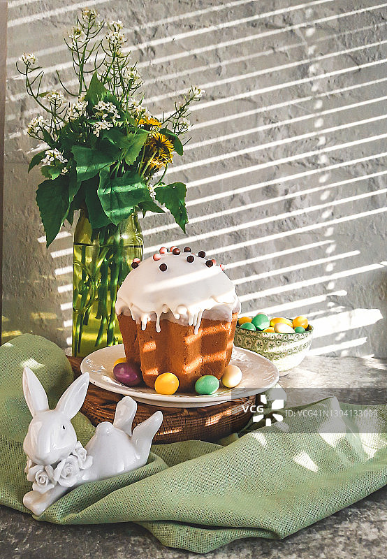 蛋糕上有白色糖衣、五颜六色的糖果和一束春天的野花。春天的新鲜的服务图片素材