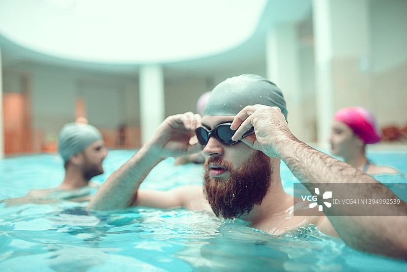 游泳护目镜为蓄须男子在游泳池图片素材