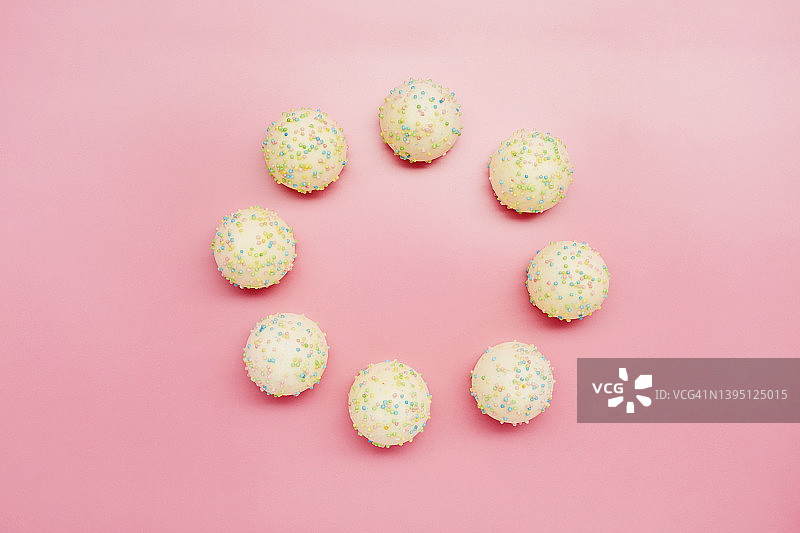 糖果在粉红色背景上排列成一个圆圈的高角度视图图片素材