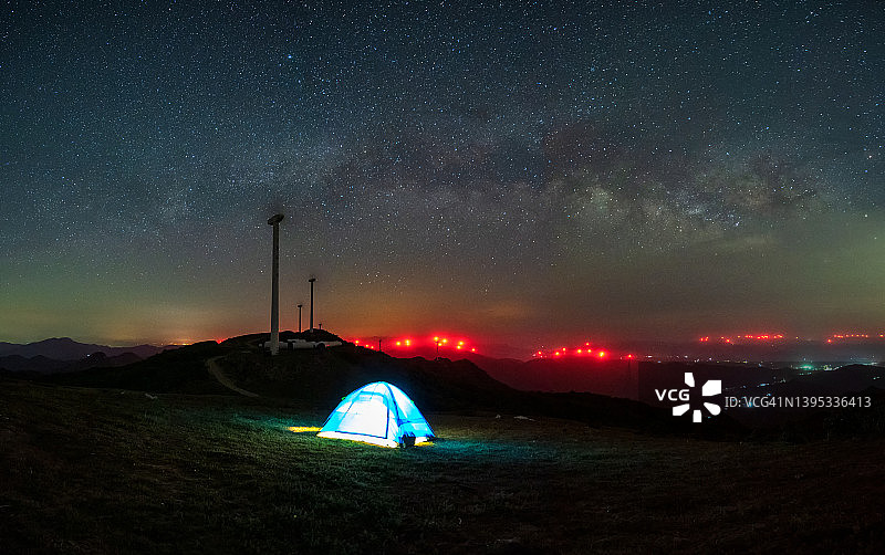 在繁星点点的夜晚，山谷里的帐篷闪闪发光图片素材