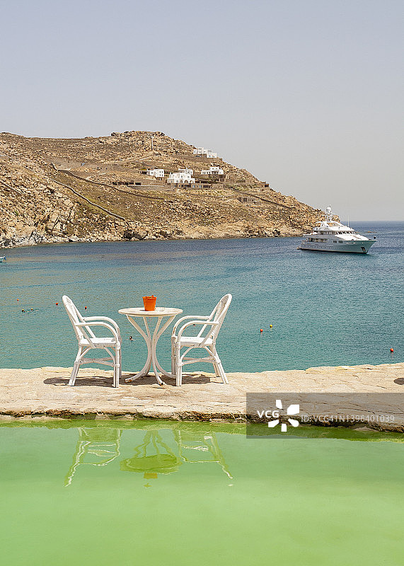 在希腊的一个小岛上，在海上的一个水池上的桌子图片素材