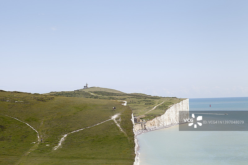夏天的景色，人们沿着白色的悬崖走到海边的灯塔图片素材