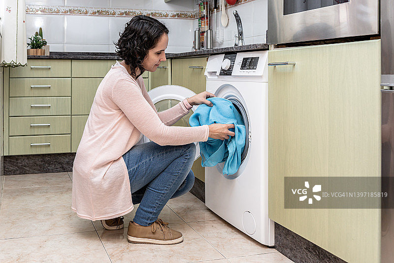 在厨房装洗衣机的女人图片素材