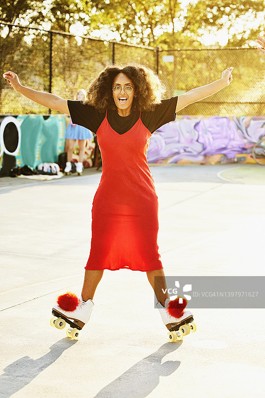 宽镜头的女人微笑和平衡的溜冰鞋图片素材