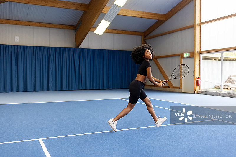 健康的年轻女子网球运动员在硬地场上比赛图片素材
