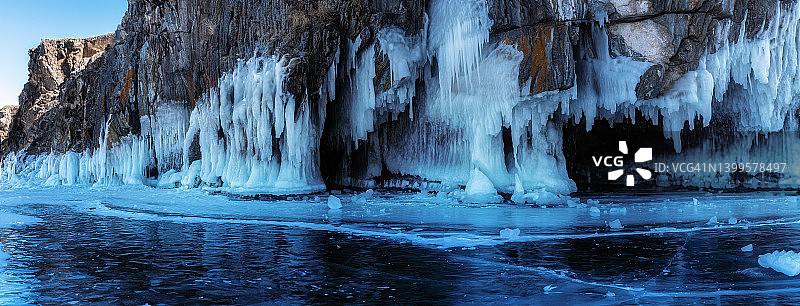 美丽的冬季全景景观与蓝色的冰洞洞穴和冰冻的清晰的冰柱。贝加尔湖，奥尔洪岛，俄罗斯。图片素材
