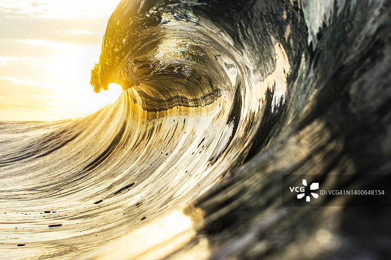 高对比明亮地照亮了海洋波浪卷曲在辉煌的金光图片素材