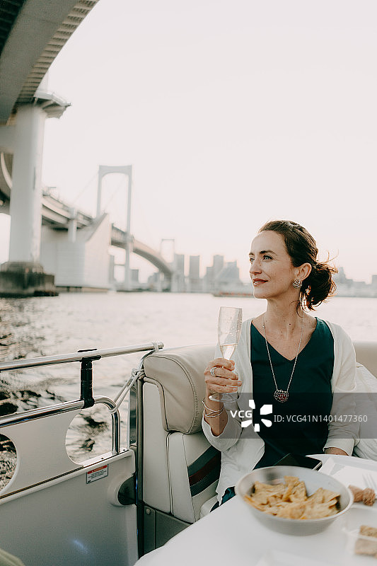 女子在彩虹桥下欣赏东京湾的游船图片素材