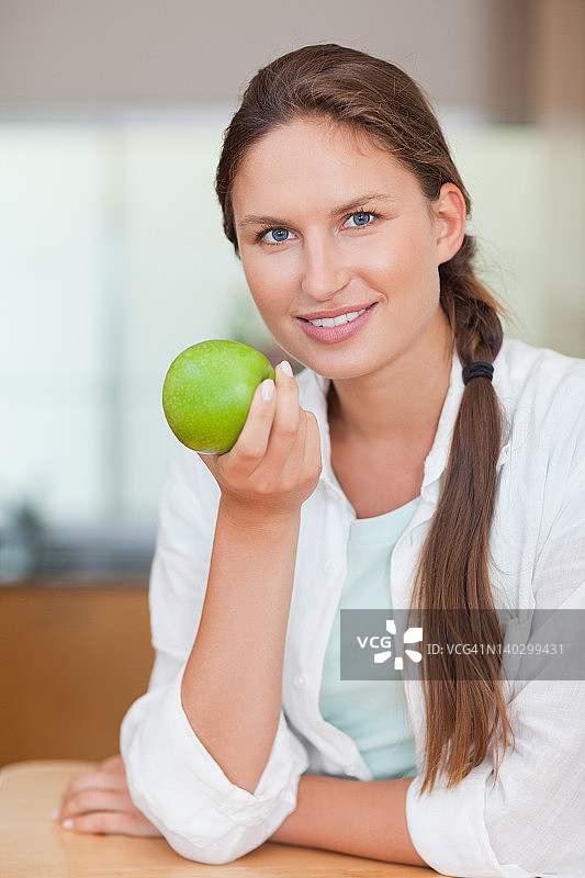 一个拿着苹果的快乐女人的肖像图片素材