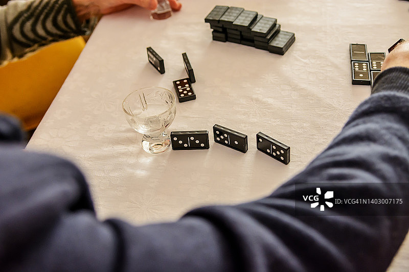 一群老年人在一个社交中心玩多米诺骨牌，玩得很开心。图片素材