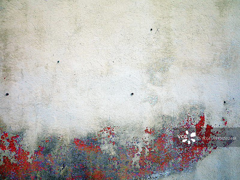 埃维安-莱斯-班斯的一堵混凝土墙上被刮花和风化的红色和白色油漆图片素材
