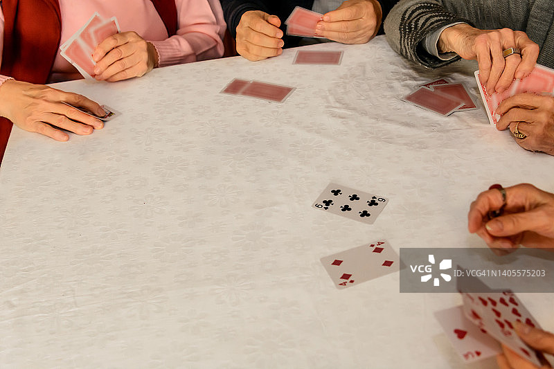 老年人在社交聚会上打牌，玩得很开心。图片素材