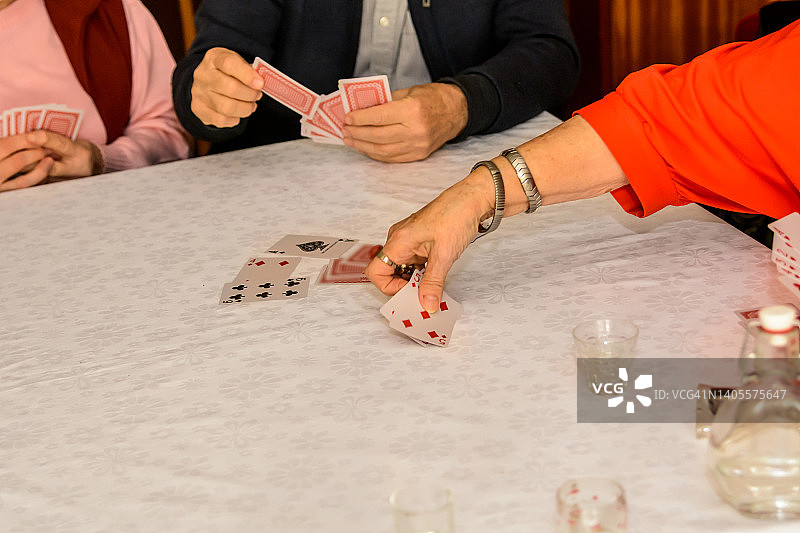 老年人在社交聚会上打牌，玩得很开心。图片素材