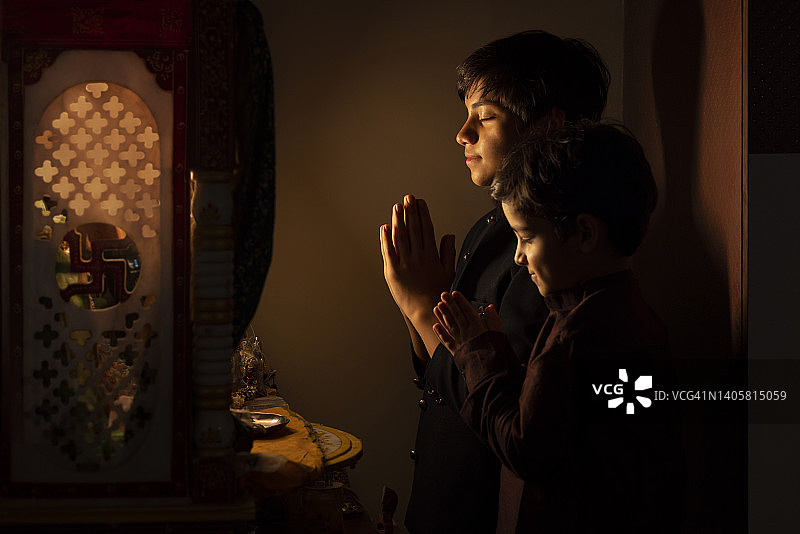 两兄弟双手合十向上帝祈祷的肖像图片素材