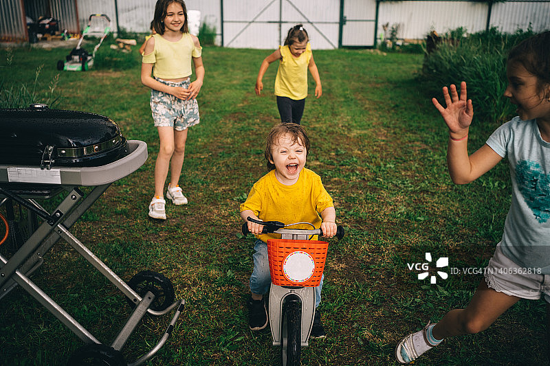 孩子在草坪上玩耍，男孩孩子骑平衡自行车，母亲节到了图片素材