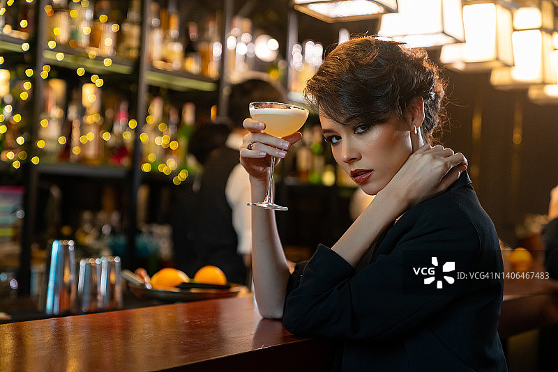 白人女人在豪华酒吧喝鸡尾酒的画像。图片素材