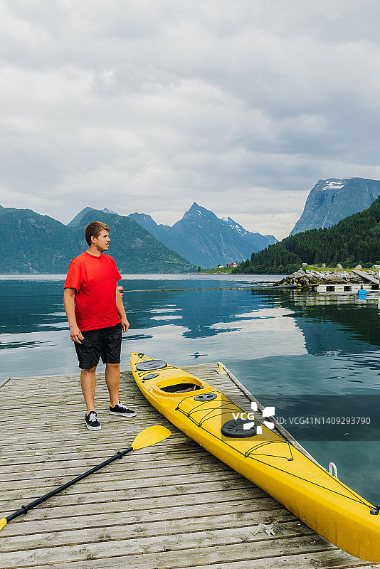 在挪威风景优美的峡湾，一名旅行者正准备划皮划艇图片素材