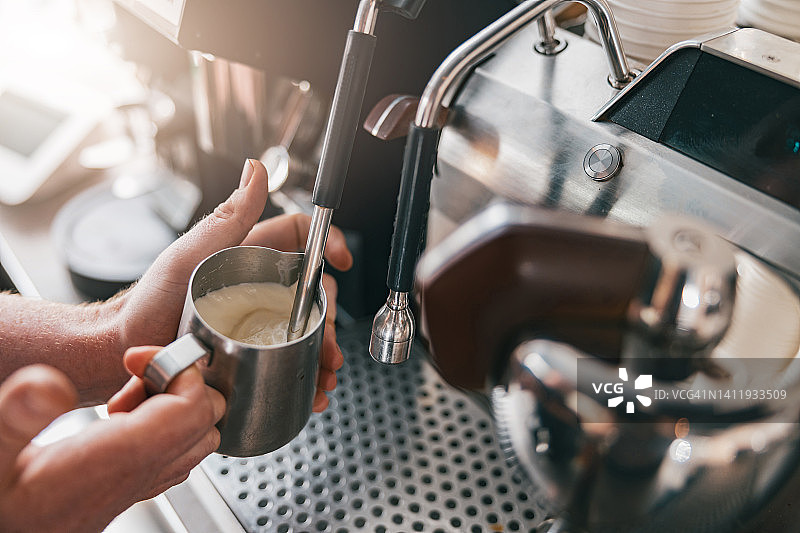 专业咖啡师用咖啡机的蒸汽加热牛奶图片素材