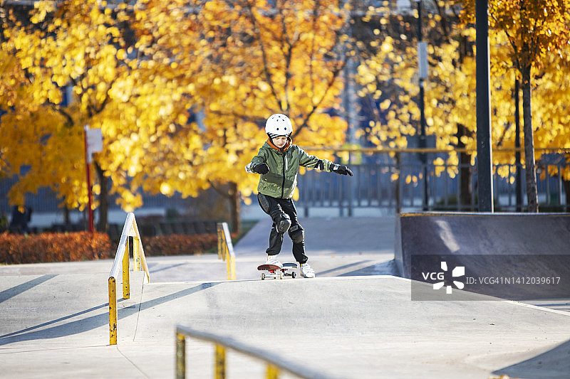 秋天，男孩在滑板公园玩滑板图片素材