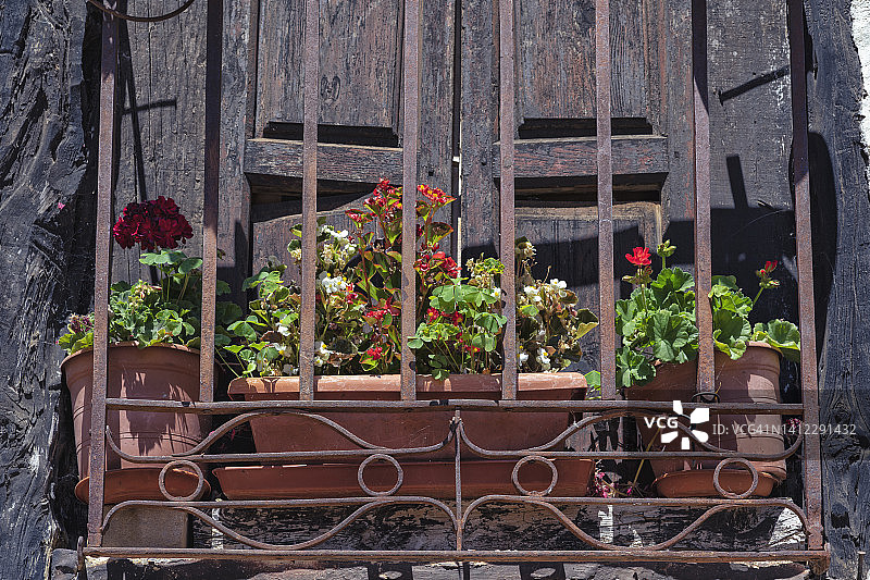 古老的乡村窗户与老式的花盒的看法。图片素材
